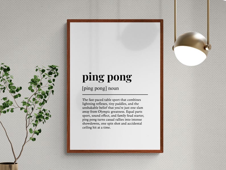 Puede incluir: Un marco con la definici&oacute;n de "ping pong" en texto negro sobre fondo blanco. La definici&oacute;n describe el ritmo r&aacute;pido del deporte y las aspiraciones ol&iacute;mpicas. El marco es de color marr&oacute;n oscuro.
