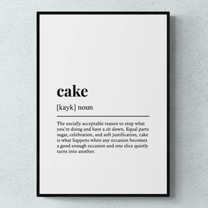 May include: A framed print with a white background and black text. The word "cake" is displayed with its pronunciation and a definition. The definition describes cake as a reason to pause, with elements of sugar and celebration.