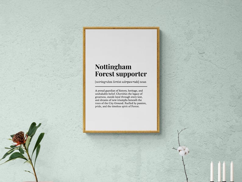 May include: A framed print with the text "Nottingham Forest supporter" in black font on a white background. The frame is gold-colored. The text includes a definition and a description of a supporter.