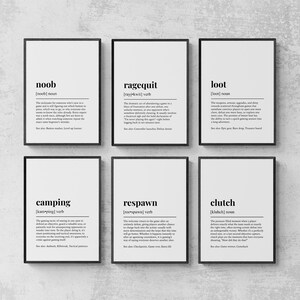 May include: A set of six framed wall art prints featuring dictionary-style definitions for gaming terms including noob, ragequit, loot, camping, respawn, and clutch. Each print displays the word, pronunciation, part of speech, and a descriptive paragraph.