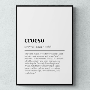 Peut inclure: Une affiche encadrée avec le mot gallois "croeso" en noir sur fond blanc. La définition de "croeso" est fournie en dessous, expliquant sa signification comme un mot gallois chaleureux pour "bienvenue".