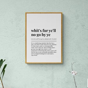 May include: A framed print with the text "whit's fur ye'll no go by ye" in black font. The print has a gold frame and is displayed on a light green wall. The text is a Scottish proverb.
