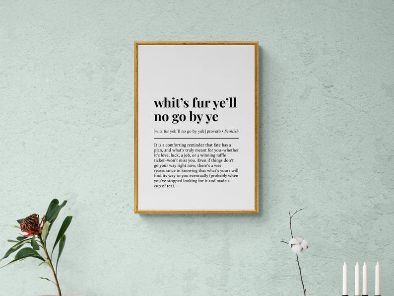 May include: A framed print with the text "whit's fur ye'll no go by ye" in black font. The print has a gold frame and is displayed on a light green wall. The text is a Scottish proverb.