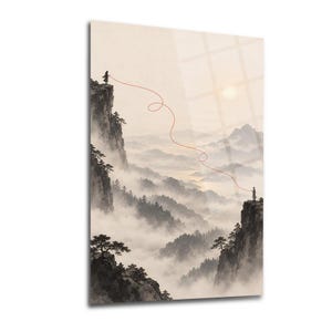 May include: A vertical wall art print depicting a misty mountain landscape in muted beige and grey tones. Two small figures stand on separate rocky cliffs, connected by a single, thin, winding red line that stretches across the foggy valley.