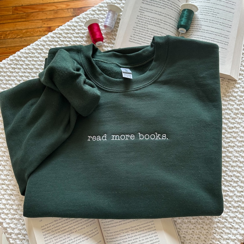 May include: A dark green sweatshirt with the text "read more books." embroidered in white on the front.