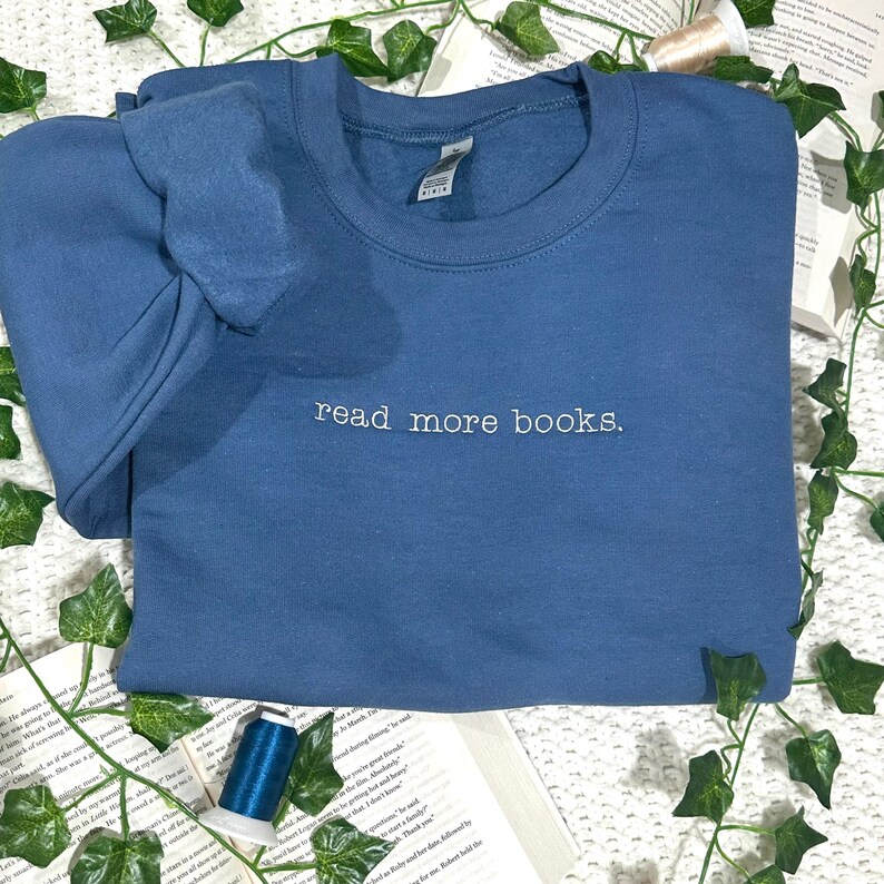 May include: A blue sweatshirt with the text "read more books." embroidered in white on the front.