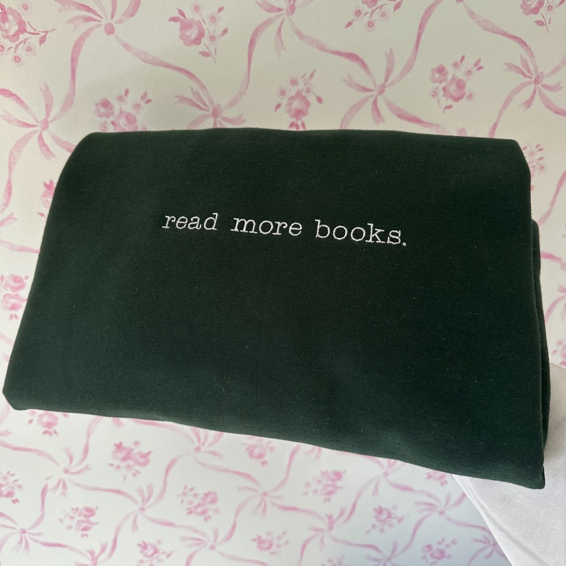 May include: A dark green sweatshirt with the text "read more books." embroidered in white.