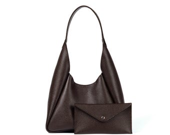 May include: A dark brown leather shoulder bag with a matching small wallet. The bag has a single handle and a slouchy design. The wallet is rectangular with a flap closure and a silver-tone button. The leather has a textured grain.