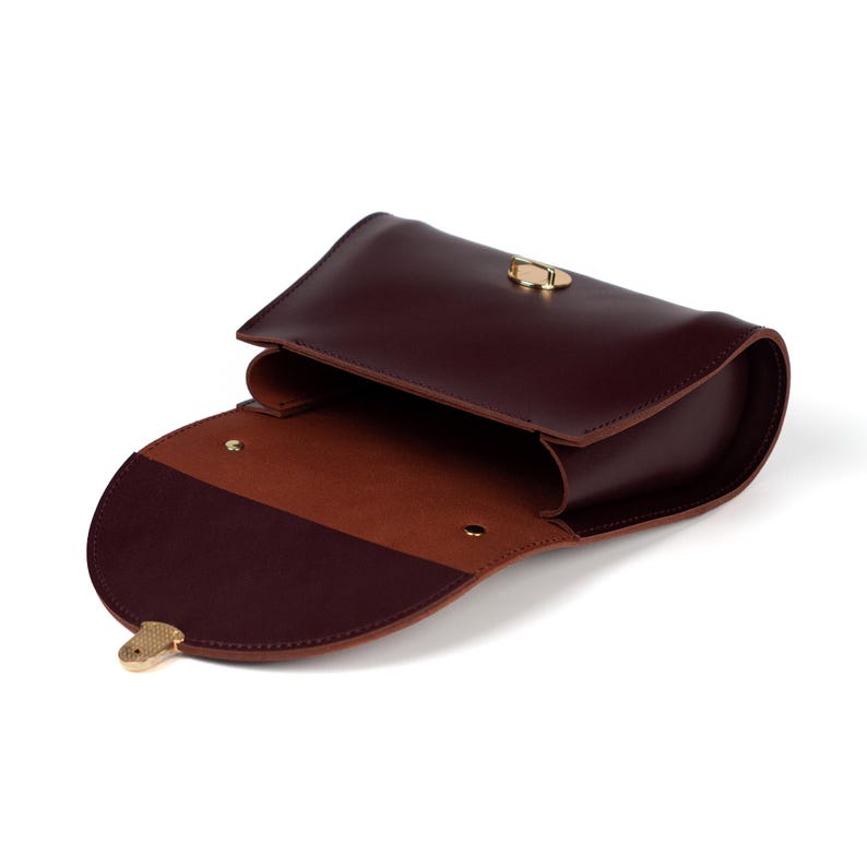 Inside view of burgundy leather handbag with open flap and suede lining.