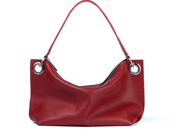 May include: A red leather handbag with a slouchy design and silver hardware. The bag has a single top handle and a zipper closure.