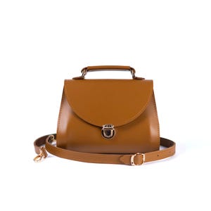 Brown leather handbag with top handle and gold clasp, structured minimalist purse.