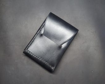 Black edc wallet with flap and quick access slot.