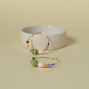 Pendientes de aro chapados en oro con cuentas de colores. Joyería llamativa y colorida para primavera.