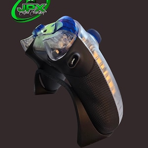 May include: Custom gaming controller with a black textured grip and clear plastic accents. The controller features blue and green details, with the "JPX Custom Controllers" logo in the upper left corner. The controller has a built-in light strip.