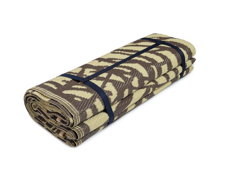 May include: A rolled up brown and beige patterned picnic mat with black straps.