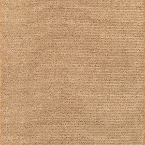 May include: A rectangular, woven rug in a natural tan color. The rug has a textured surface with a repeating horizontal pattern. The edges are finished with a darker border.