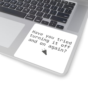 May include: A white sticker with black text that reads "Have you tried turning it off and on again?" with a black plug icon below the text.