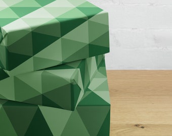 May include: Three green gift boxes with a geometric pattern. The boxes are stacked on top of each other.