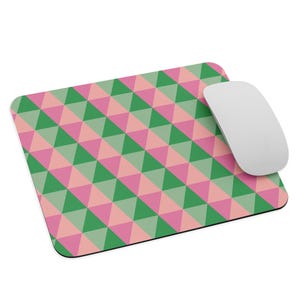 May include: A pink and green geometric mouse pad with a repeating pattern of triangles. The mouse pad is made of a soft, durable material and is designed to protect your desk from scratches and wear.