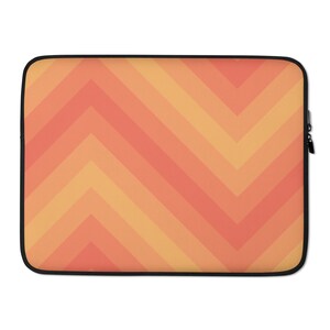 Puede incluir: Una funda para portátil con un patrón geométrico de rayas de chevron naranja y amarillo.