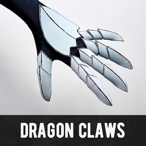 May include: A black and white dragon claw costume with articulated finger segments. The claws are light gray with black outlines, attached to a black sleeve. The text "DRAGON CLAWS" is displayed in white on a black banner.