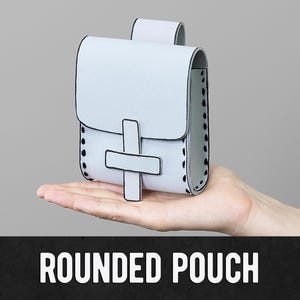 May include: A pale grey rounded pouch with a flap and a cross-shaped clasp. The pouch has black trim and is held in a hand. The text "ROUNDED POUCH" is displayed in bold white letters at the bottom of the image.