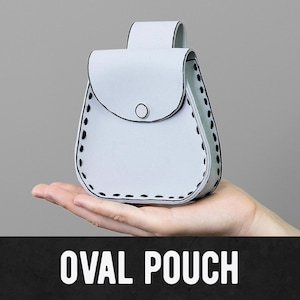 May include: A light blue oval pouch with a flap closure and a button. The pouch has black stitching around the edges and a loop at the top. The text "OVAL POUCH" is displayed in white letters on a black background.