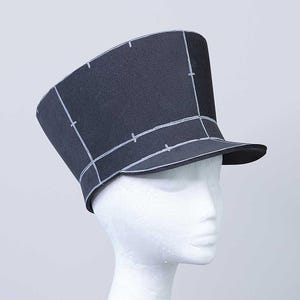 May include: A black felt hat with a wide brim and a tall crown. The hat is marked with white lines, creating a grid pattern.