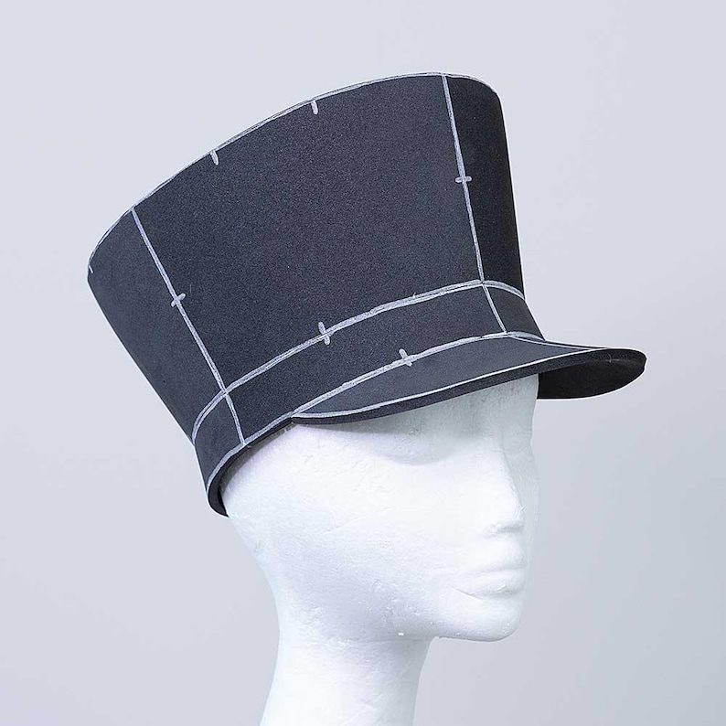 May include: A black felt hat with a wide brim and a tall crown. The hat is marked with white lines, creating a grid pattern.