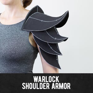 May include: Black shoulder armour featuring a layered, leaf-like design with visible white stitching lines along the edges of each segment. The piece is worn on the upper arm and is labelled with the text WARLOCK SHOULDER ARMOR at the bottom.