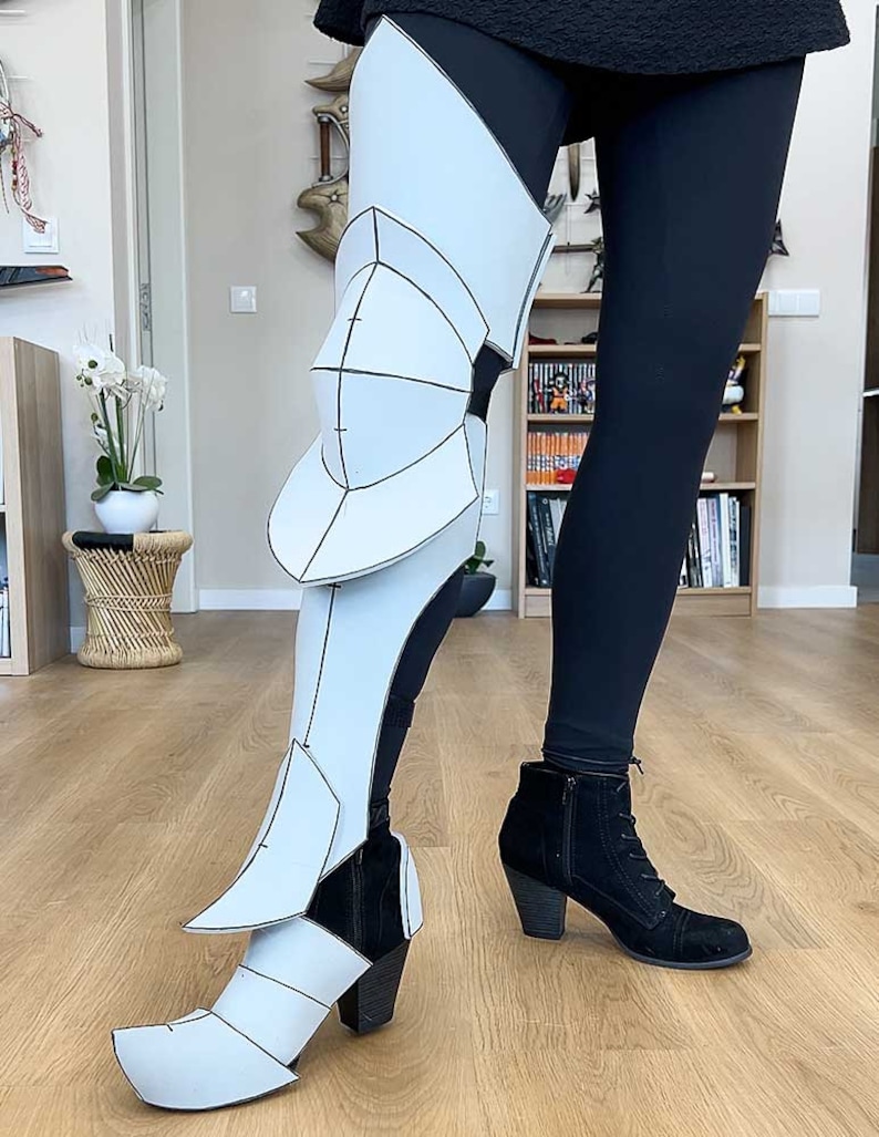 May include: A white foam leg armor with black lines and a black boot with a heel.
