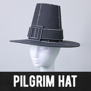 Könnte beinhalten: Ein schwarzer Pilgerhut mit breiter Krempe und hohem, leicht konischem Oberteil. Der Hut hat eine weiße Schnalle und einen Riemen. Der Text "PILGRIM HAT" wird in weißen Blockbuchstaben am unteren Bildrand angezeigt.