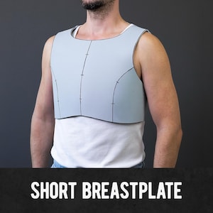Könnte beinhalten: Ein hellblaues kurzes Brustpanzer mit schwarzen Kanten und Nahtdetails. Das Brustpanzer wird über einem weißen Unterhemd getragen. Der Text "SHORT BREASTPLATE" wird in weißen Blockbuchstaben am unteren Bildrand angezeigt.