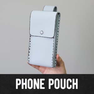 May include: A light blue phone pouch with a flap closure and a button. The pouch has black stitching along the edges and a loop at the top. The words "PHONE POUCH" are displayed in white text at the bottom.