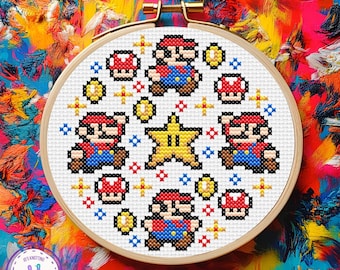 May include: A cross-stitch embroidery hoop with a pixelated design of the video game character Mario, mushrooms, coins, and a star. The design is in red, blue, yellow, and black. The hoop is set against a colourful, abstract background.