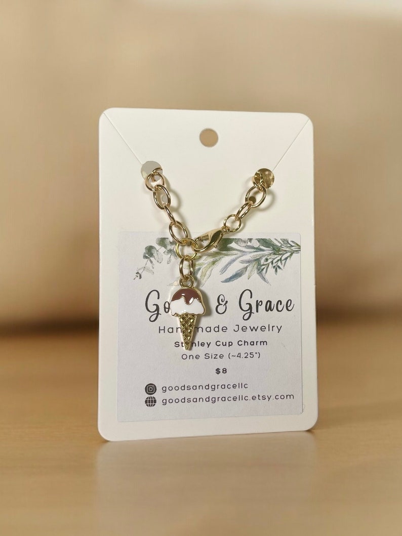 May include: A gold chain bracelet with a charm of a brown and white ice cream cone. The charm is attached to a gold lobster clasp. The bracelet is on a white card with the text "Go & Grace Handmade Jewelry Stanley Cup Charm One Size (-4.25") &pound;8 goodsandgracelic goodsandgracelic.etsy.com"