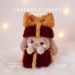 Könnte beinhalten: Ein gehäkeltes Spielzeug-Kaninchen mit braunem Körper, das ein bordeauxfarbenes Outfit und eine große Schleife trägt. Der Text "CROCHET PATTERN HOLLY HOP" steht oben. Die Texte "advanced beginner" und "low-sew" stehen unten.