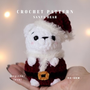 Könnte beinhalten: Häkelanleitung für einen Weihnachtsbären. Der Bär ist weiß mit roter Weihnachtsmütze und Anzug. Der Text "CROCHET PATTERN SANTA BEAR" steht oben. Die Texte "beginner level" und "no-sew" stehen unten.