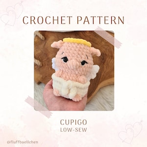 Könnte beinhalten: Häkelanleitung für einen rosa Schweinchen-Engel-Amigurumi mit einem gelben Heiligenschein und weißen Flügeln. Das Muster heißt "Cupigo Low-Sew".