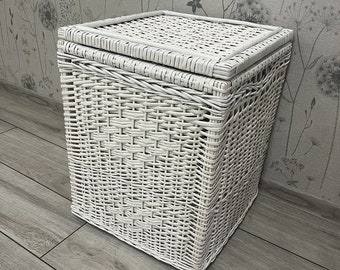 Op de afbeelding: Witte rieten opbergmand met deksel. De mand is geweven met een strak, ingewikkeld patroon.