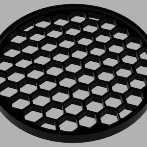 May include: A black, circular object featuring a honeycomb design. The object has a raised, rounded edge and a series of hexagonal openings. The design is symmetrical and appears to be made of a solid material.