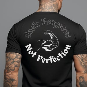 Puede incluir: Camiseta negra de cuello redondo con texto y gráficos blancos. La parte delantera de la camiseta tiene el texto "Seek Progress, Not Perfection" en un diseño circular. La parte trasera de la camiseta tiene el mismo texto y un gráfico de un brazo flexionándose.