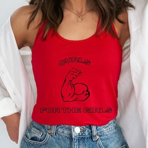 May include: A red tank top with the text "CURLS FOR THE GIRLS" in black. The graphic features a flexing arm. The tank top is sleeveless and has a scoop neck.