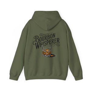 May include: A green hooded sweatshirt with the text "Bourbon Whisperer" and a drawing of a glass of bourbon on the back.