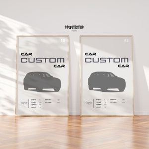 May include: Two framed posters with the text "CAR CUSTOM CAR" in black and white. Each poster features a silhouette of a car in gray against a white background. The posters have a white border and are displayed on a wooden floor.