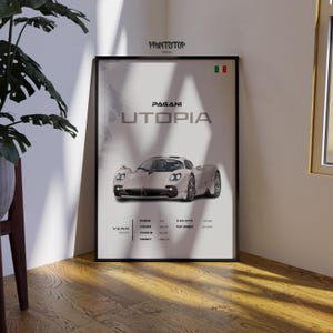 May include: Framed poster featuring a silver Pagani Utopia sports car. The poster includes the car's name, "Utopia," and technical specifications. The Italian flag is in the upper right corner. The poster is in a black frame.