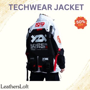Op de afbeelding: Een wit en zwart techwear jack met rode accenten. Het jack heeft een groot "HYPER ZERO" logo op de rug en een kleiner logo op de linkermouw. Het jack heeft meerdere zakken en banden.