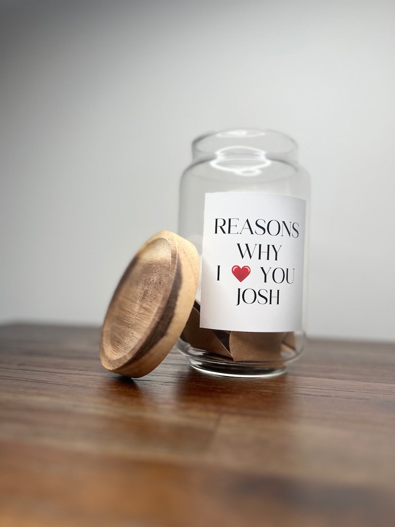 May include: A glass jar with a wooden lid filled with small pieces of paper. The jar has a label that says "Reasons Why I &hearts; You Josh".