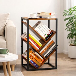 Puede incluir: Una estanter&iacute;a moderna con una tapa de madera marr&oacute;n oscuro y estantes en &aacute;ngulo. Los estantes est&aacute;n llenos de libros de varios tama&ntilde;os y colores. El marco es de metal negro. Una taza de t&eacute; y un platillo blancos est&aacute;n encima.