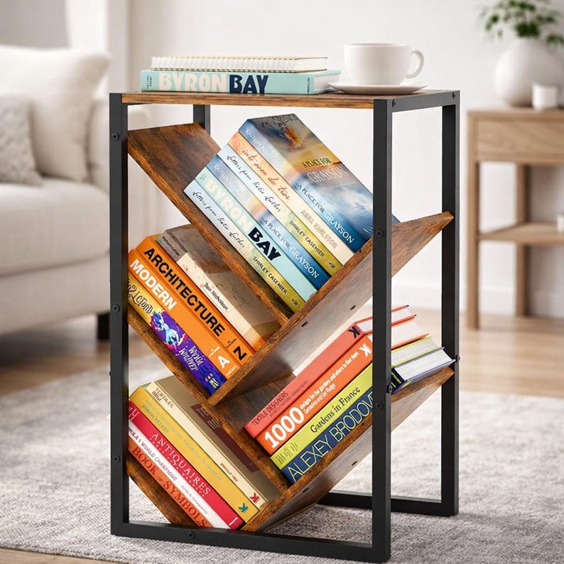 Puede incluir: Mesa auxiliar de madera oscura y metal negro, con estantes inclinados para libros. La mesa exhibe varios libros con t&iacute;tulos visibles. Una taza de t&eacute; blanca descansa en la parte superior. Las dimensiones son en cent&iacute;metros.
